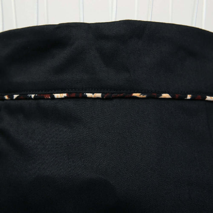Close-up of the black pencil skirt showcasing leopard piping detail for a sophisticated look.