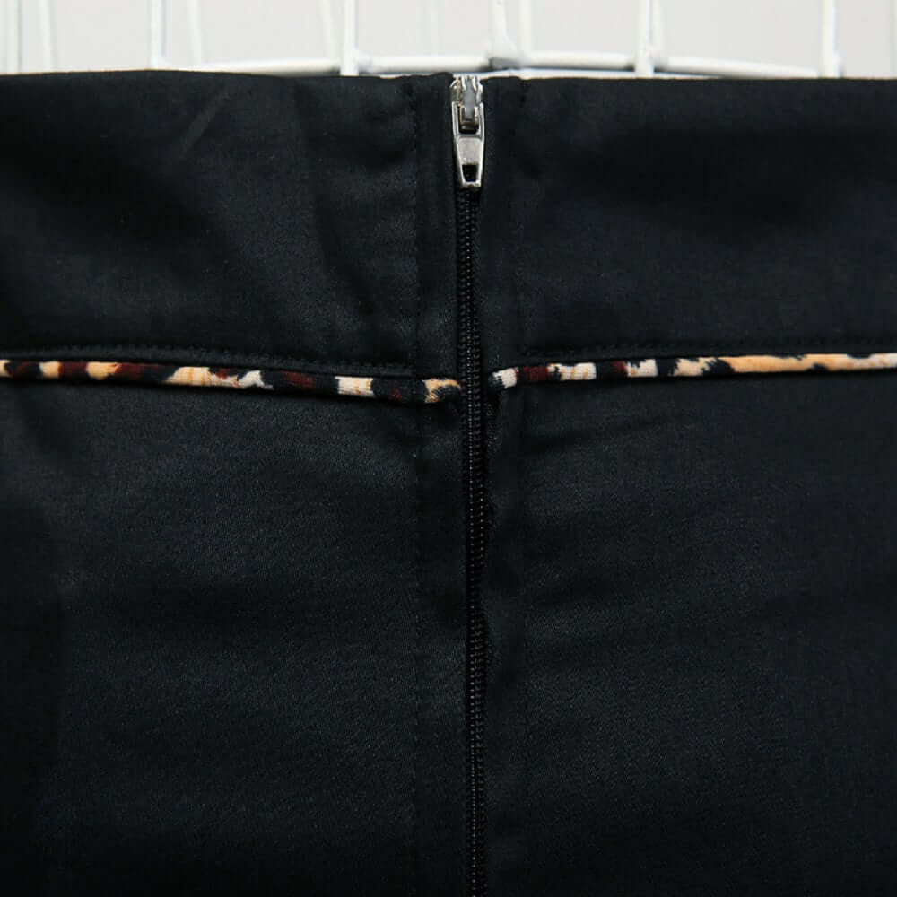 Back view of the black pencil skirt featuring leopard piping and a sleek zip closure.