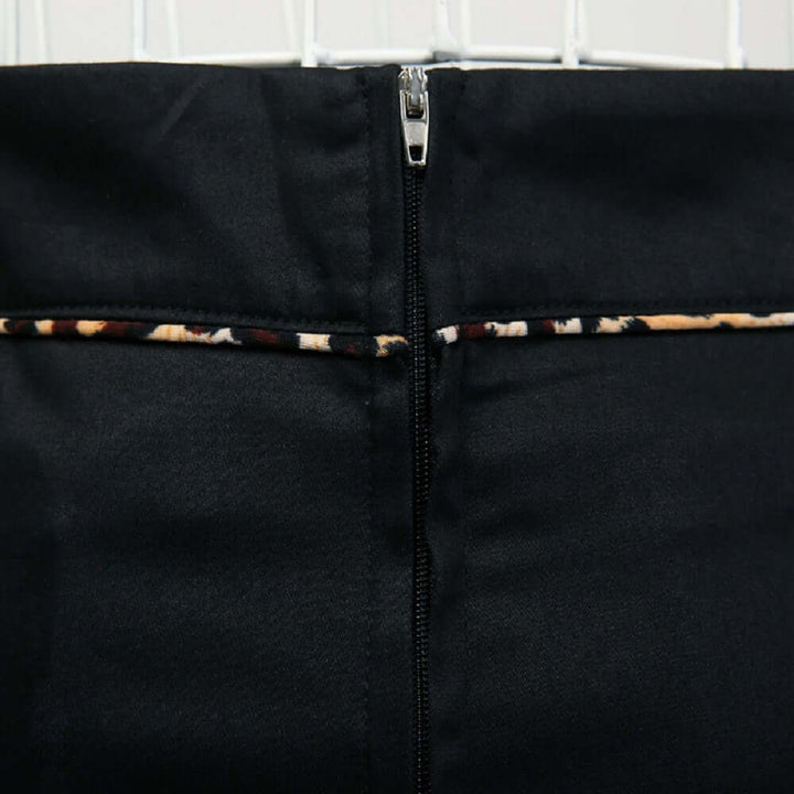 Back view of the black pencil skirt featuring leopard piping and a sleek zip closure.