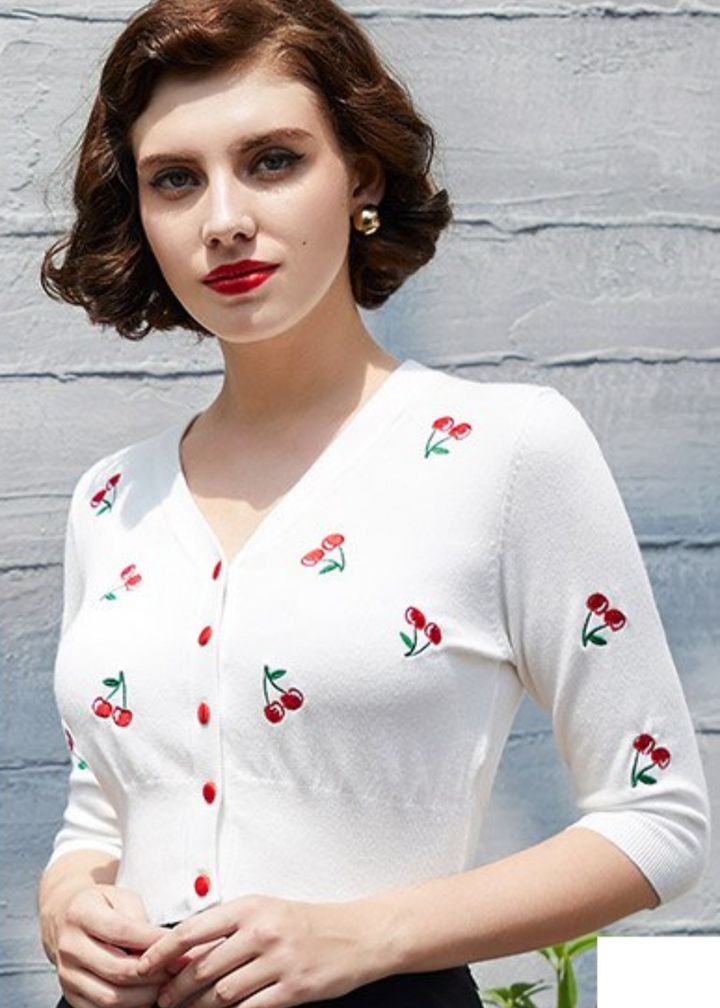 Cropped cherry cardigan with embroidered cherries, worn by a model with vintage-inspired hairstyle and red lips.
