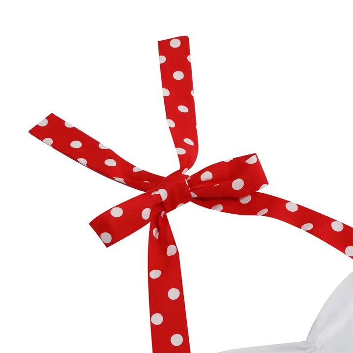 Close-up of red polka dot ribbon tie on a girls' Rockabilly dress, showcasing playful design details.