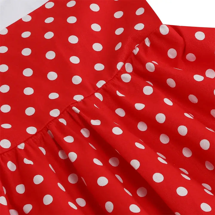 Close-up of red polka dot fabric for girls halter rockabilly dress, showcasing playful design and cotton material.