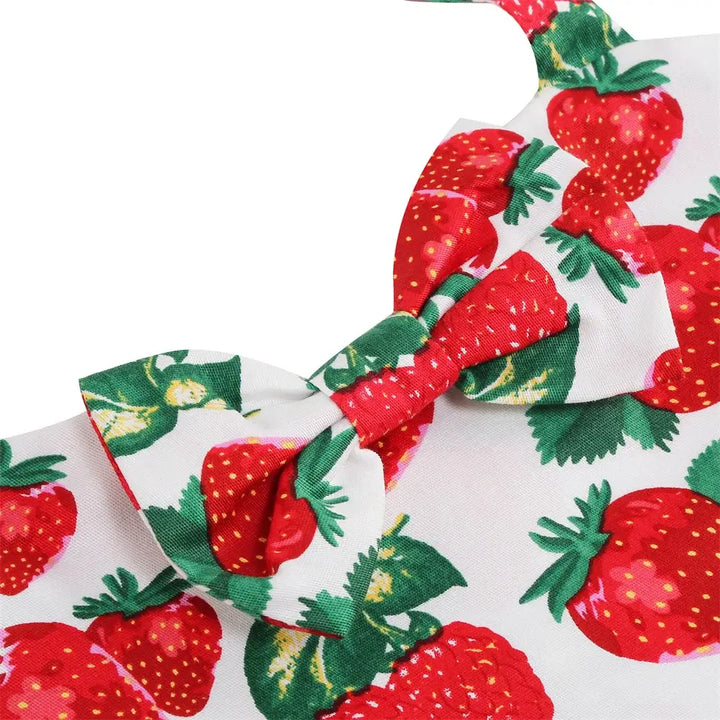Close-up of the bow on a girls' strawberry print halter rockabilly dress with vibrant red strawberries and green leaves.