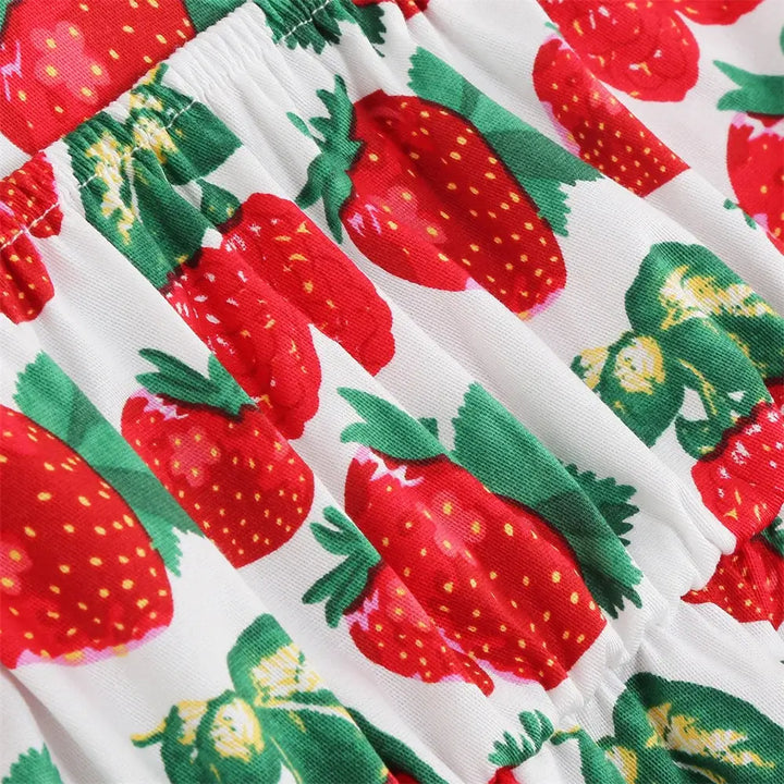 Close-up of playful strawberry print fabric on Girls Strawberry Halter Rockabilly Dress for a fun summer look.