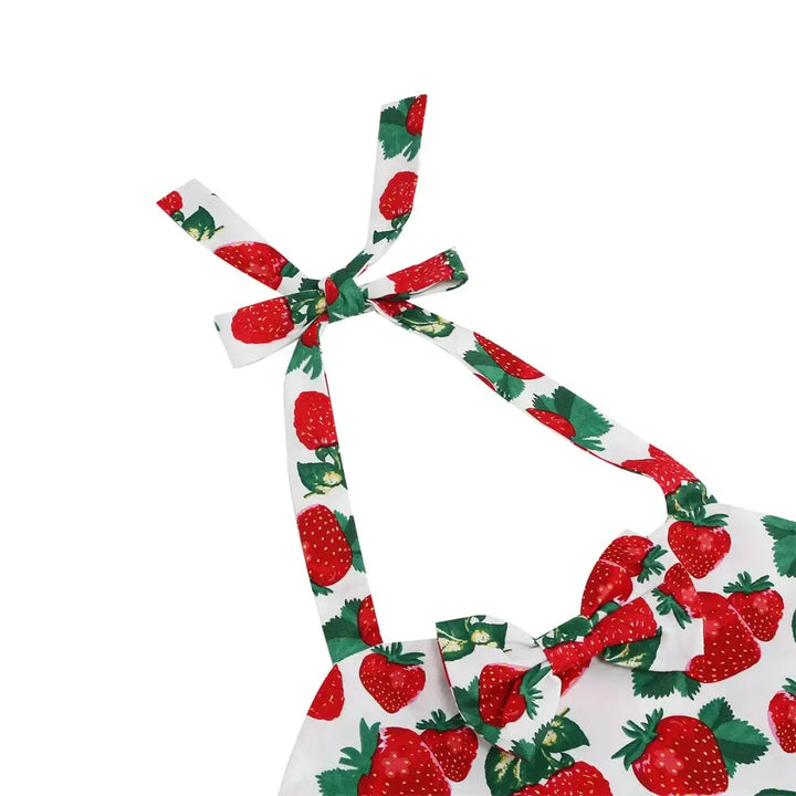 Close-up of the straps of a girls' strawberry halter rockabilly dress featuring vibrant strawberry print.