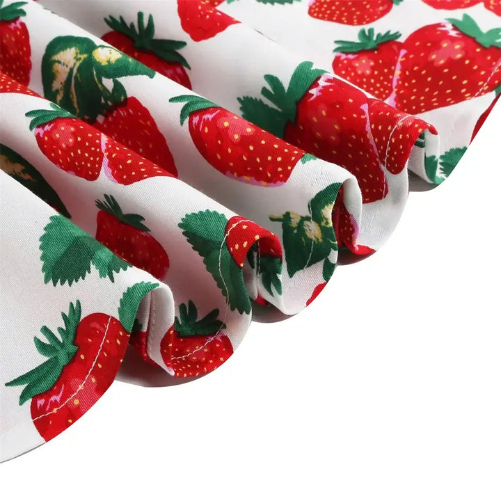 Close-up of cotton fabric featuring vibrant strawberry print for Girls Strawberry Halter Rockabilly Dress.