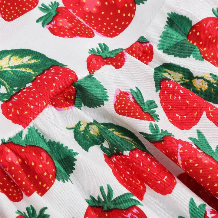 Close-up of playful strawberry print on cotton fabric for girls' halter rockabilly dress.