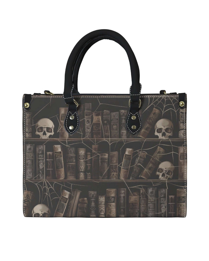 Vintage-style handbag featuring a spooky library design with skulls and spider webs, perfect for dark academia fashion.
