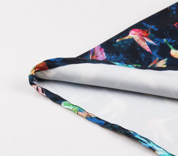 Hummingbird Print Sweetheart Halter A-Line Dress fabric detail showcasing vibrant hummingbird print on navy blue background.