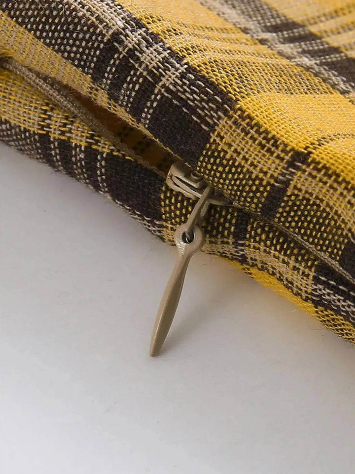 Close-up of the zipper detail on the Lucille plaid dress highlighting its chic yellow and black plaid fabric.