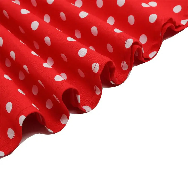 Close-up of the red polka dot fabric showcasing playful white dots for a halter rockabilly dress.