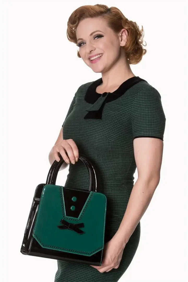 Model showcasing Rosemary's Bag teal handbag with bow detail, wearing a retro-chic outfit.