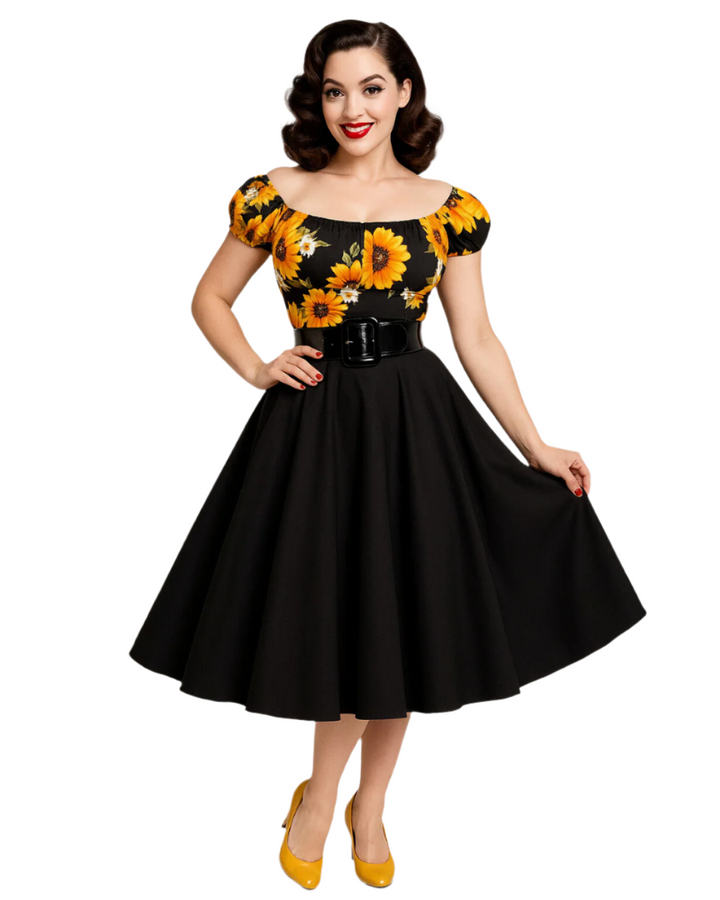 Woman wearing a black dress with yellow floral patterns on a white background