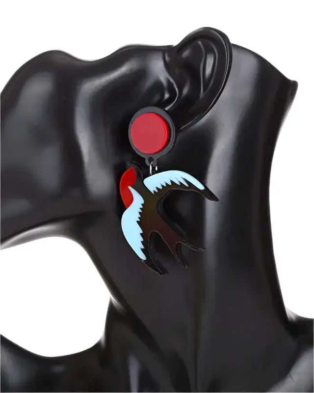 SWALLOWS acrylic drop earrings on mannequin ear, featuring colorful pinup style design and zinc alloy stud post.
