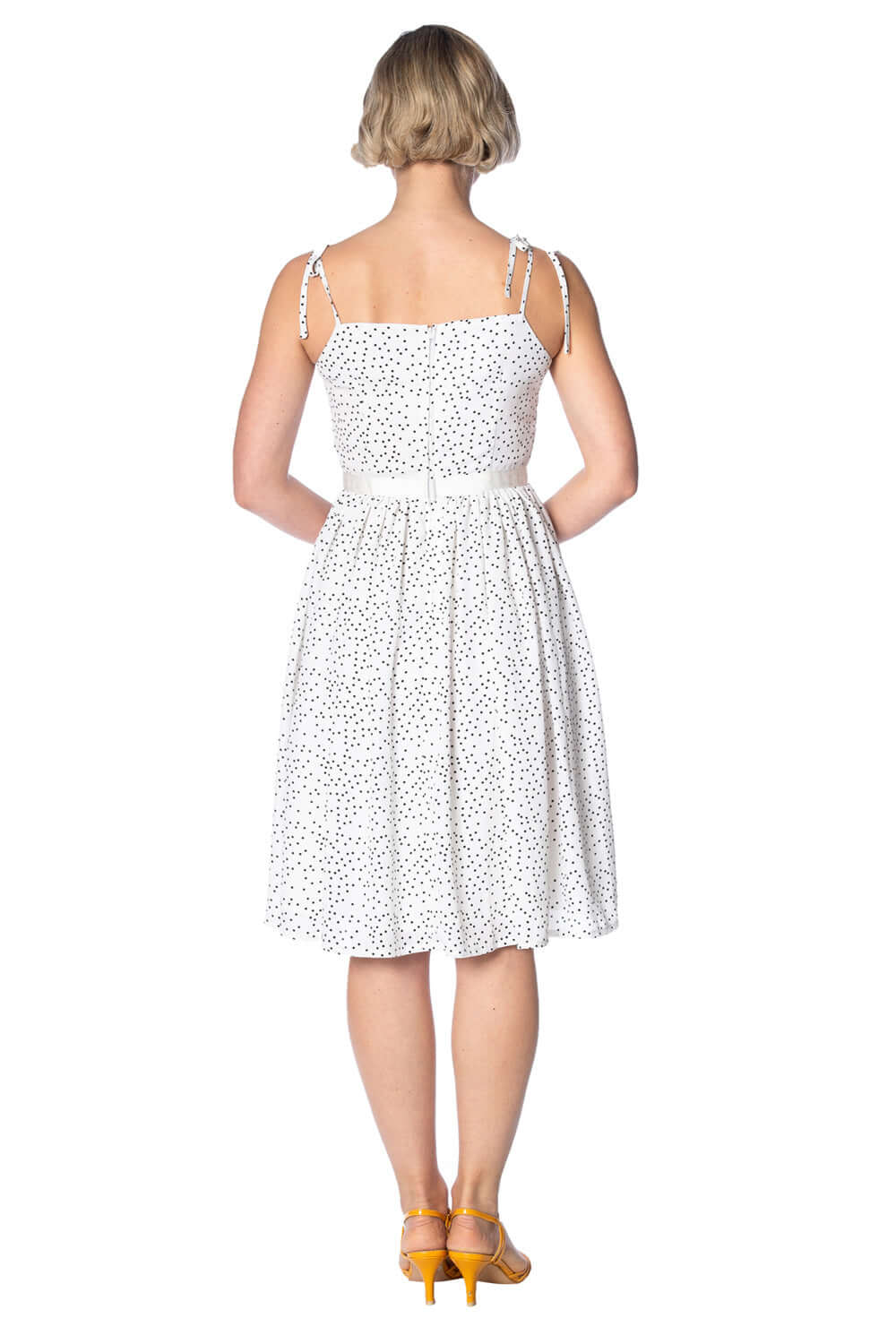 Back view of the Sweet Spot Strappy Dress in white with polka dots, featuring spaghetti straps and a waist belt detail.