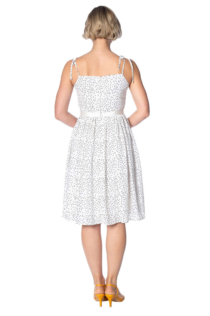Back view of the Sweet Spot Strappy Dress in white with polka dots, featuring spaghetti straps and a waist belt detail.