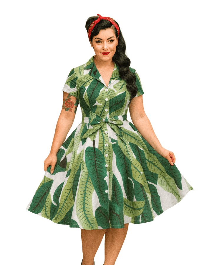 Model wearing a Tropical Leaves Vintage Swing Dress with a playful leaf pattern and retro style.