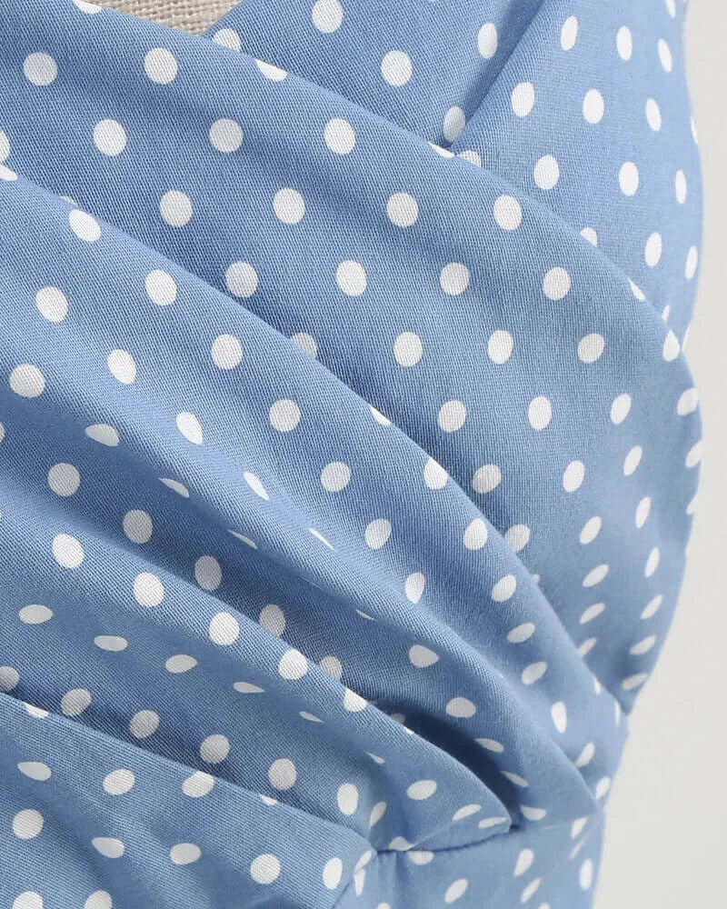 Blue fabric with white polka dots on a plain background