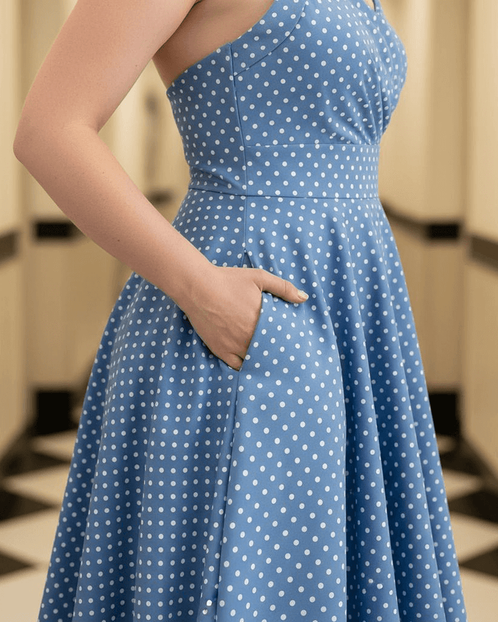 Woman wearing a blue polka dot dress in a bathroom setting