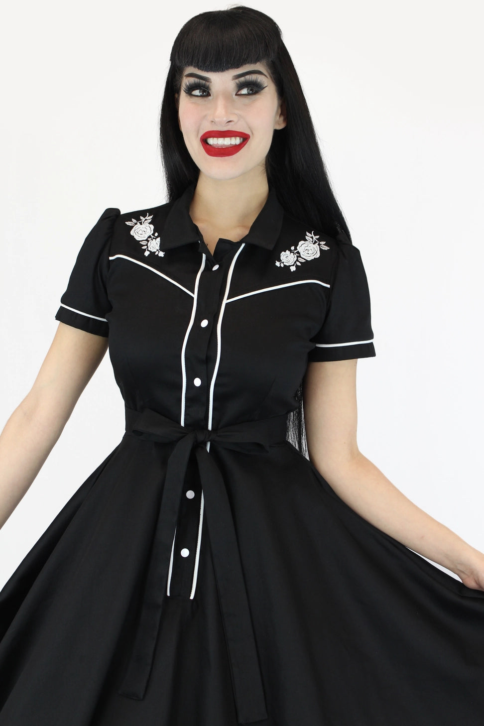 Woman wearing a black dress with white accents on a white background