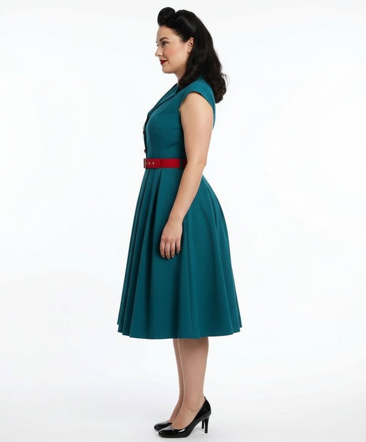 Woman wearing a teal dress with a red belt on a white background