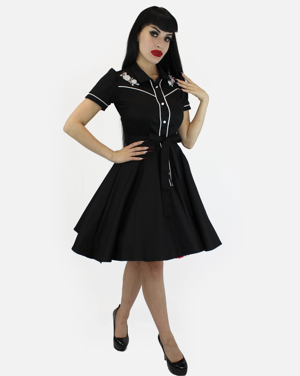 Woman wearing a black dress with white trim on a white background