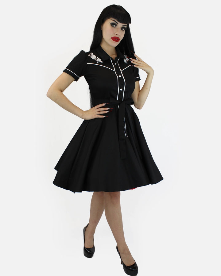 Woman wearing a black dress with white trim on a white background
