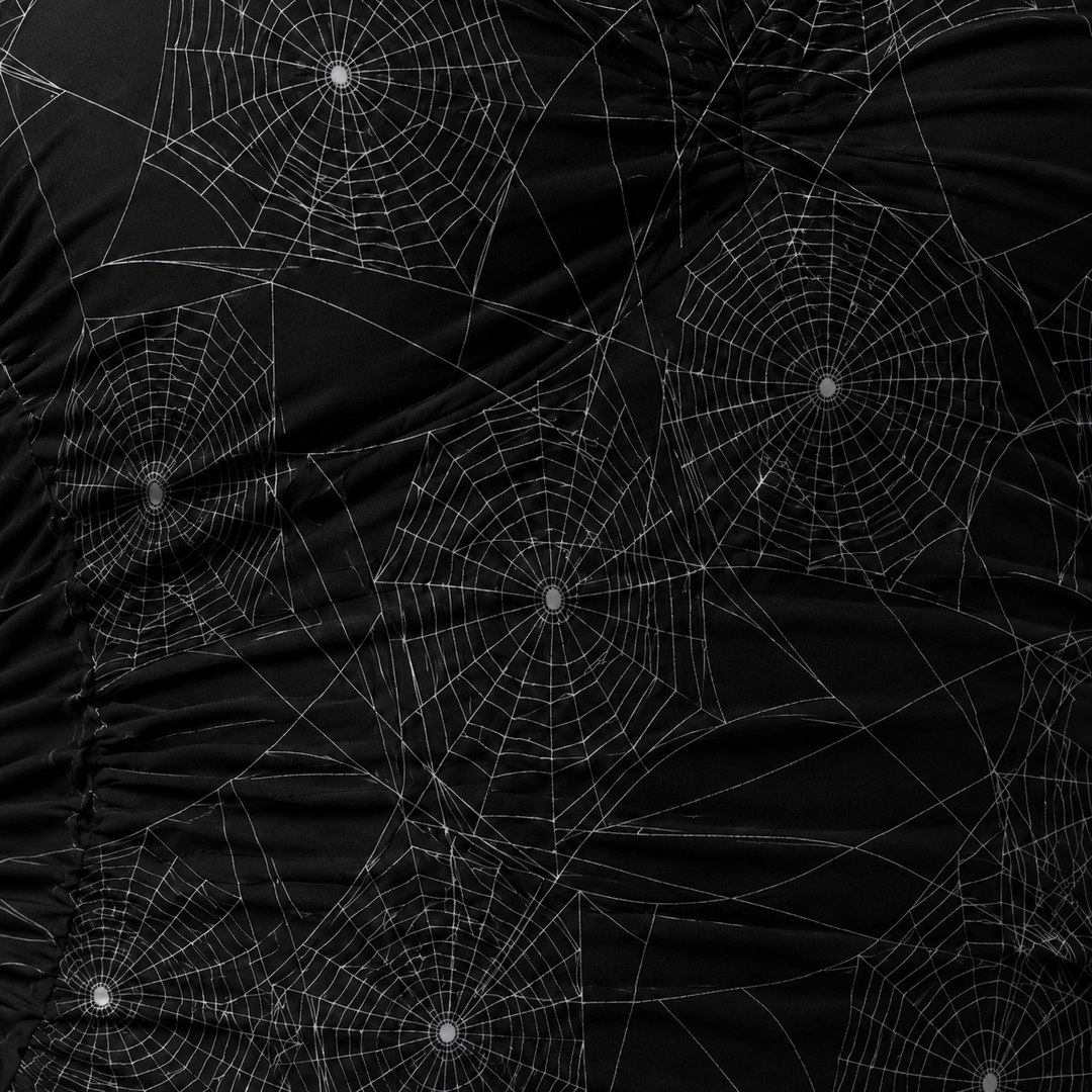 Black fabric with spider web patterns on a dark background