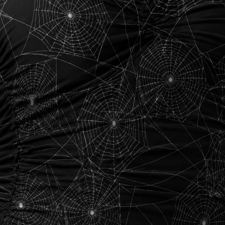 Black fabric with spider web patterns on a dark background