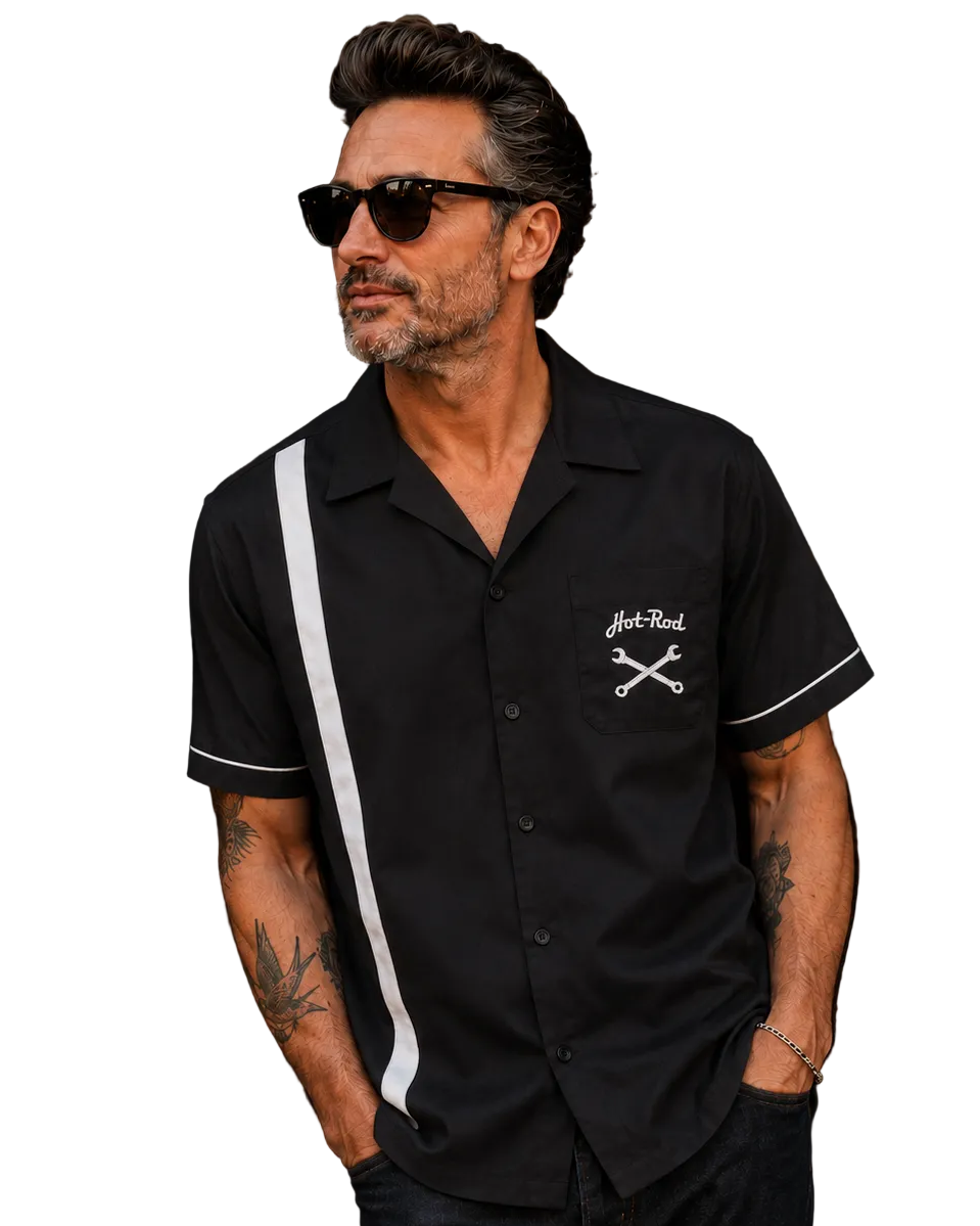 A man wearing a black short-sleeve button-up camp collar shirt with a white vertical stripe on the shoulder and sleeve, and a white embroidered chest graphic reading 'Hot-Rod' with crossed tools. He is also wearing black sunglasses, set against a plain white background.
