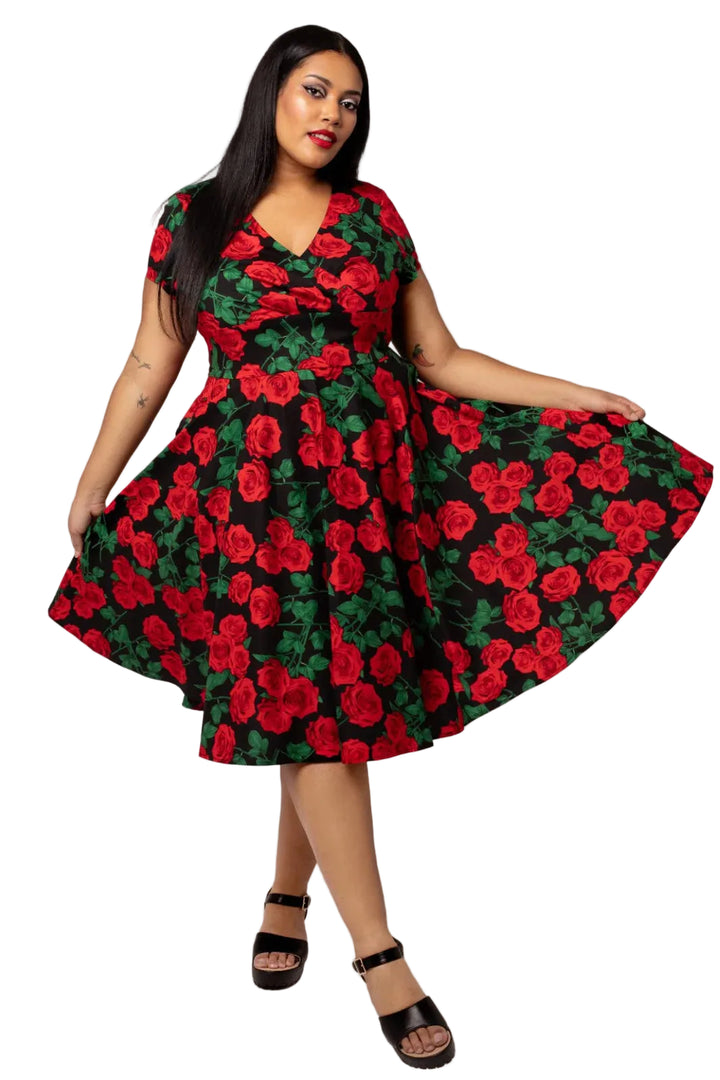 Woman wearing a red and green floral dress on a white background
