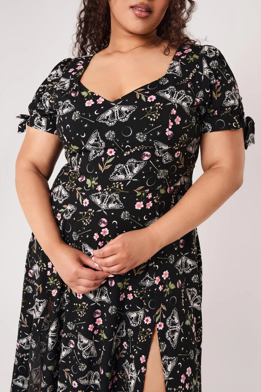 Close up of Hell Bunny Chrysalis Dress black moth moon and floral print fabric