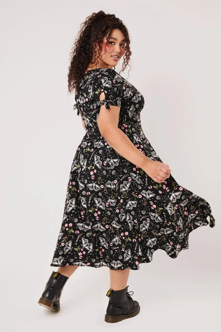 Plus size model wearing Hell Bunny Chrysalis black moth print midi dress with boots