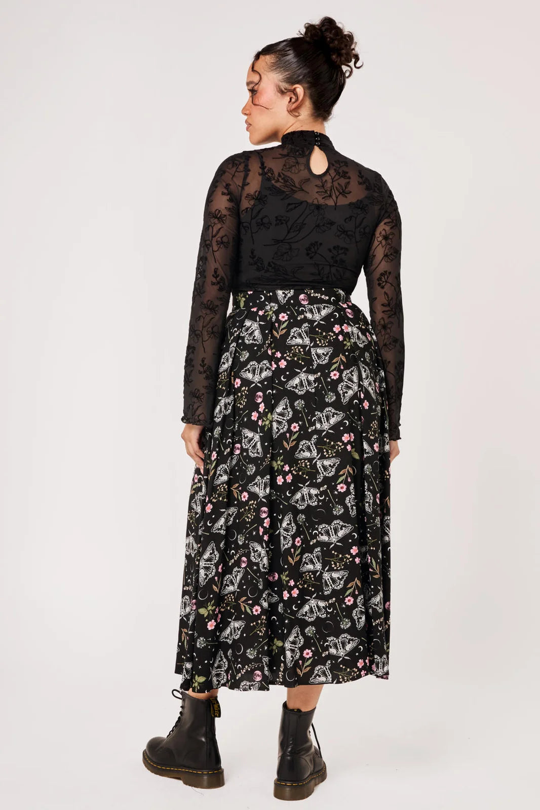 Back view of Hell Bunny Chrysalis black moth print midi skirt styled with boots