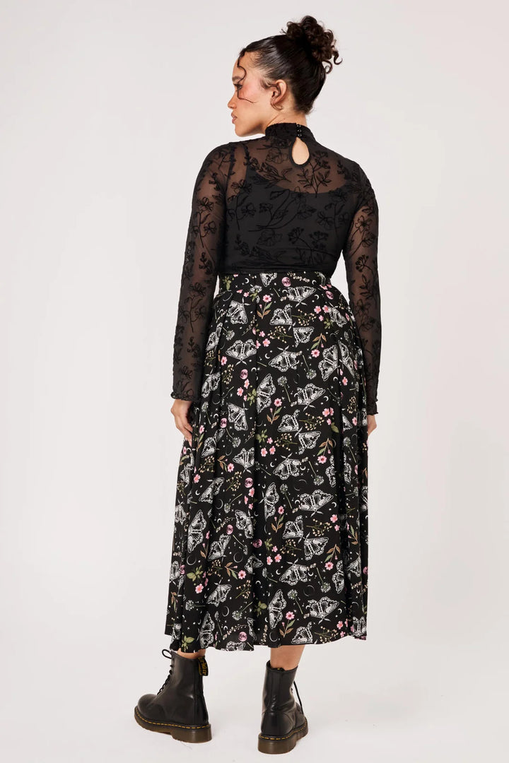 Back view of Hell Bunny Chrysalis black moth print midi skirt styled with boots