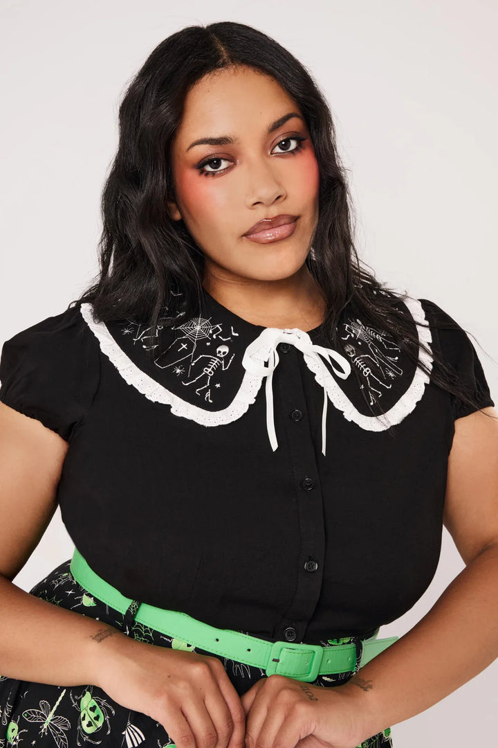 Plus size model wearing Hell Bunny Danse Macabre black skeleton collar blouse
