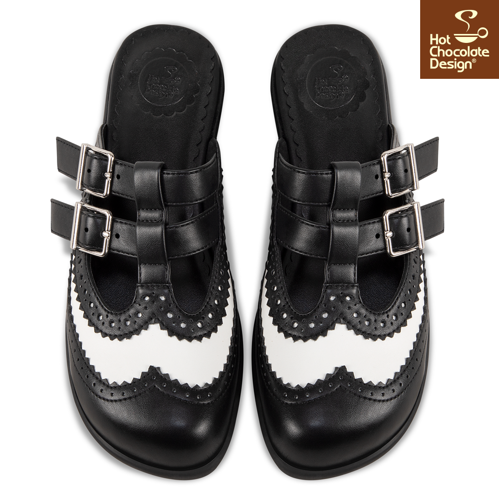 Black and white shoes with buckles on a white background, featuring Hot Chocolate Design logo.