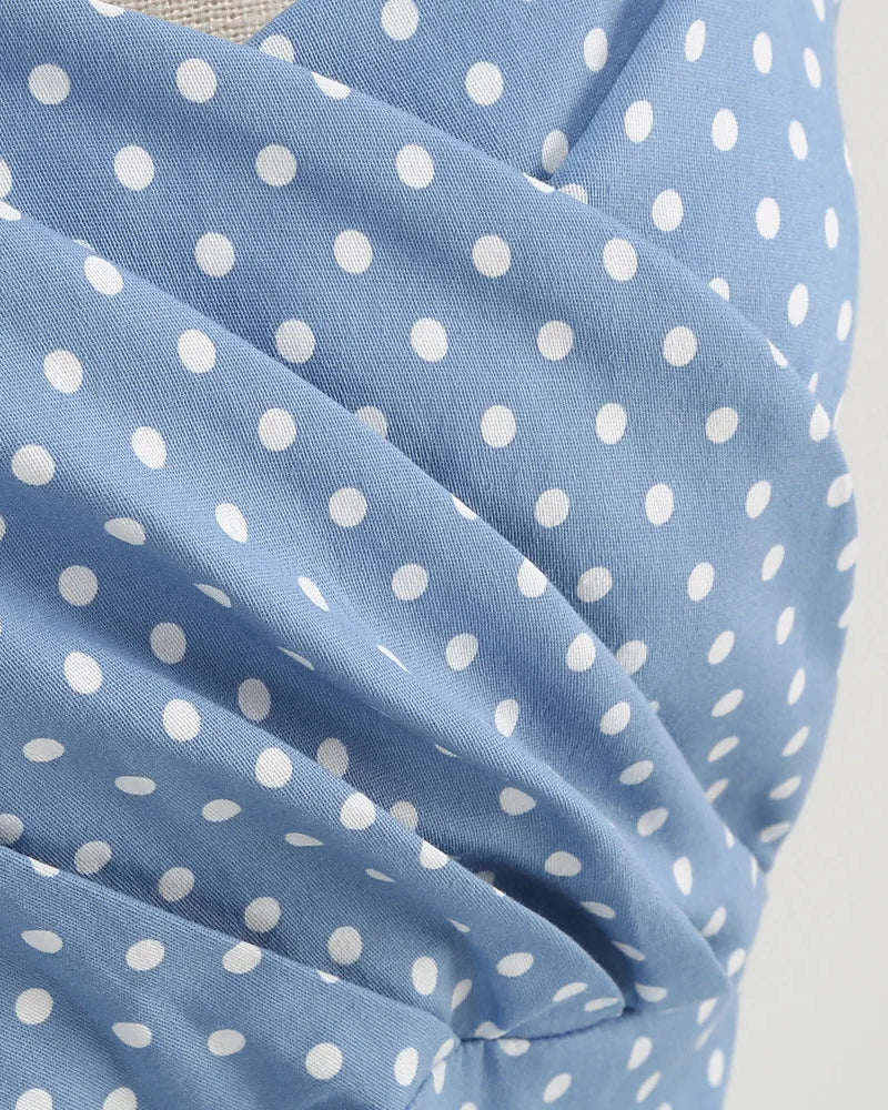 Blue fabric with white polka dots on a plain background