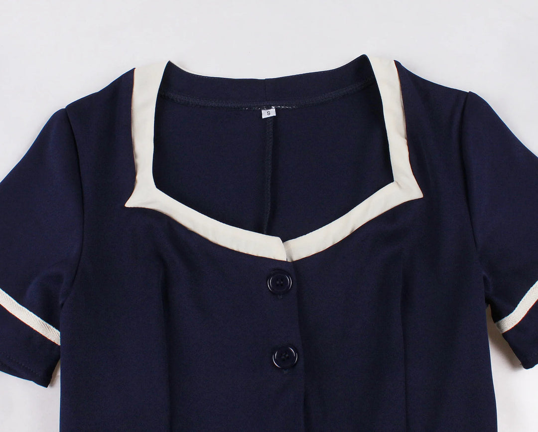 Navy blue outfit with white trim on a light gray background
