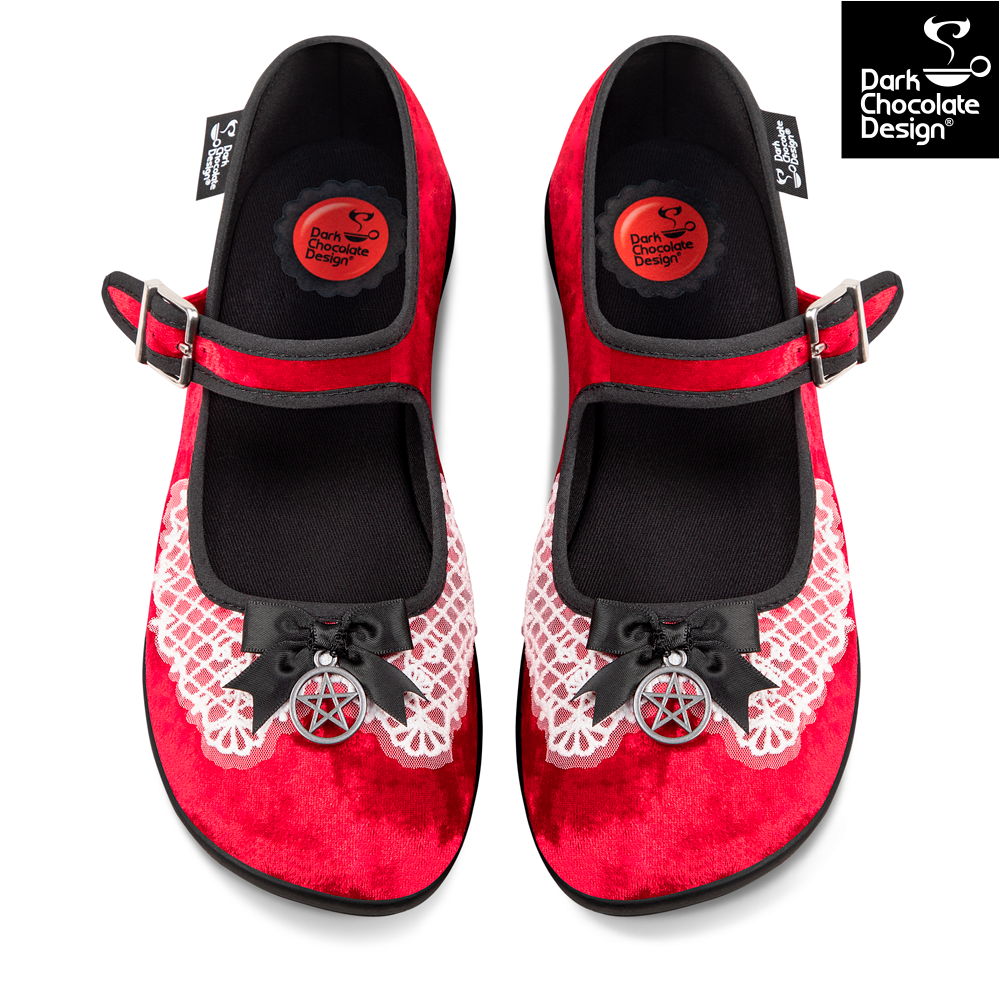 Red shoes with black bows and pentacle designs on a white background, featuring Dark Chocolate Design logo.