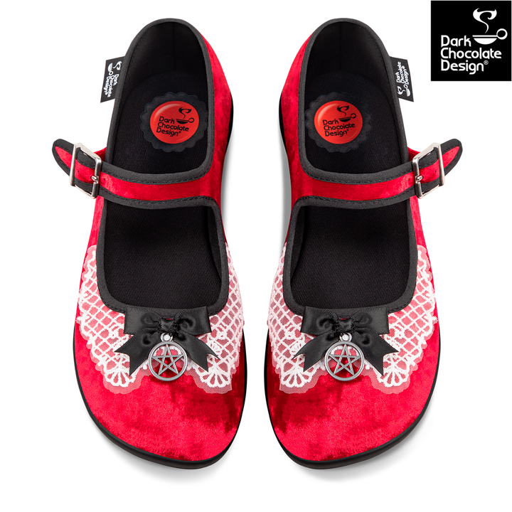 Red shoes with black bows and pentacle designs on a white background, featuring Dark Chocolate Design logo.