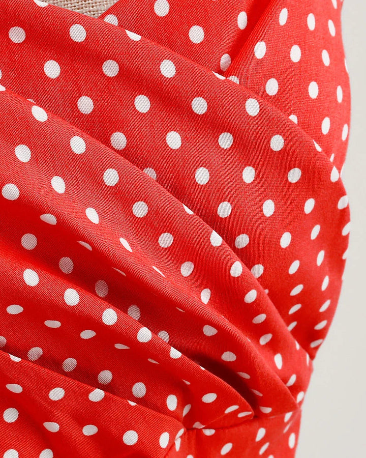 Red fabric with white polka dots on a plain background