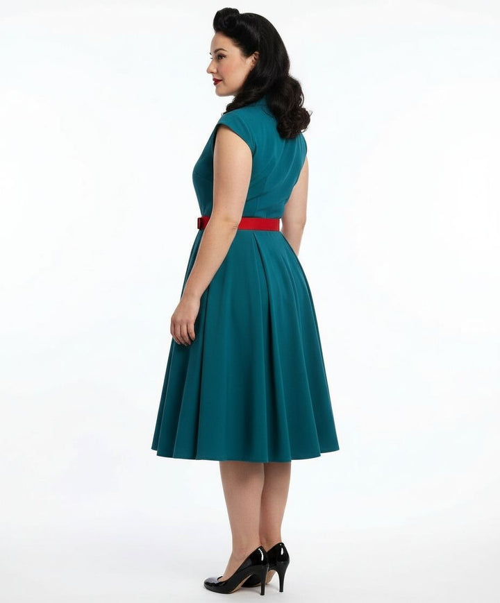 Woman wearing a teal dress with a red belt on a white background