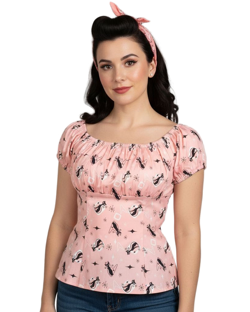 Woman wearing a pink top with black cats on a white background