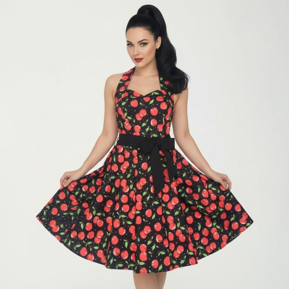 Woman wearing a dress with red cherry pattern on a white background
