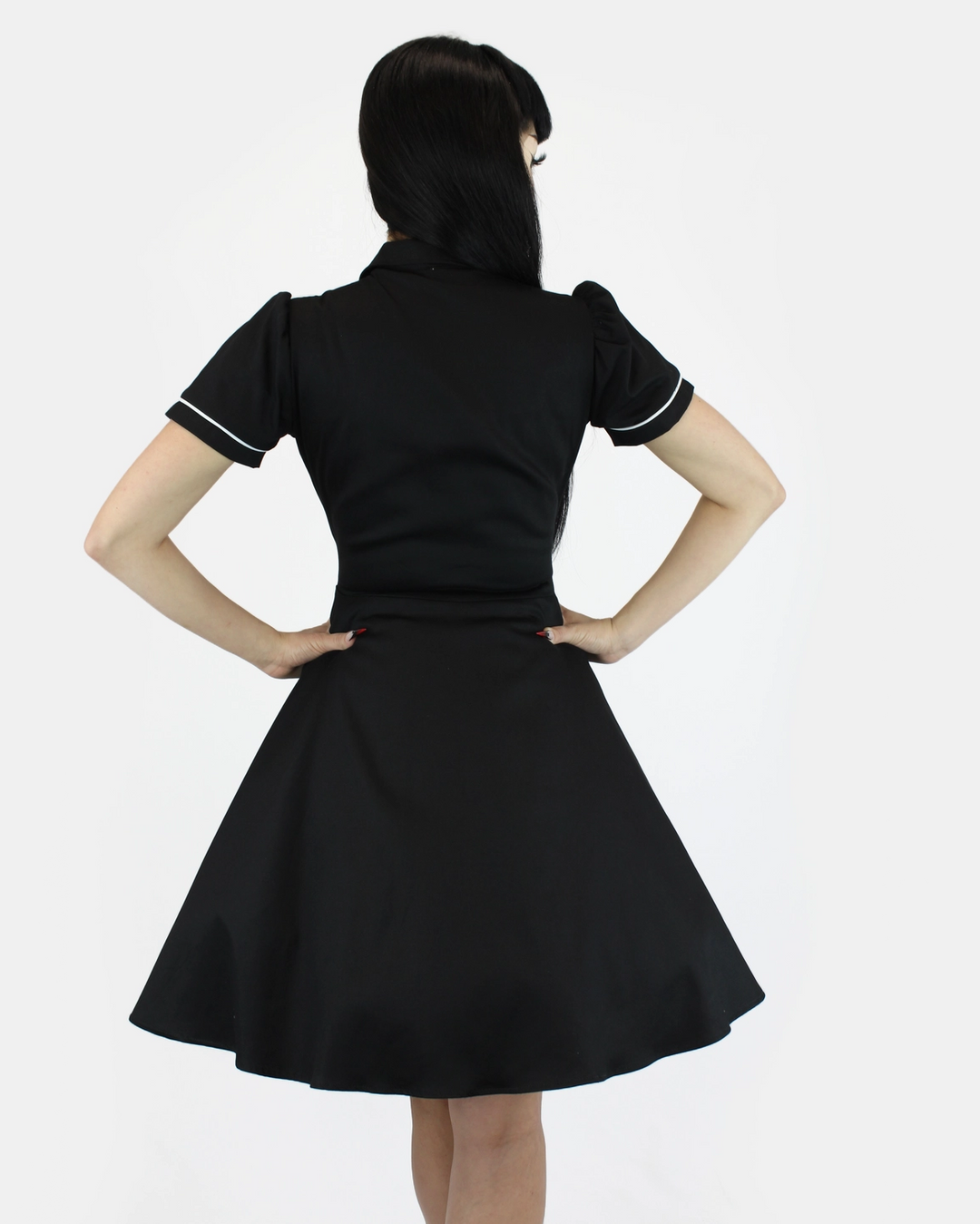 Black dress with white trim worn by a person on a white background