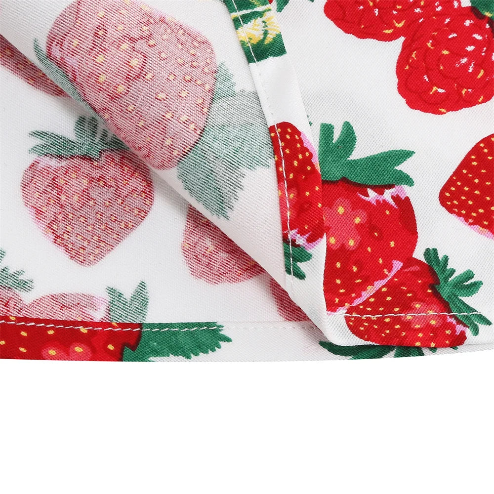 Close-up of playful strawberry print on girls' halter rockabilly dress, featuring vibrant reds and greens.