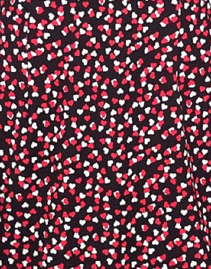 Close up of Liquorbrand heart print fabric with red white and pink hearts on black background