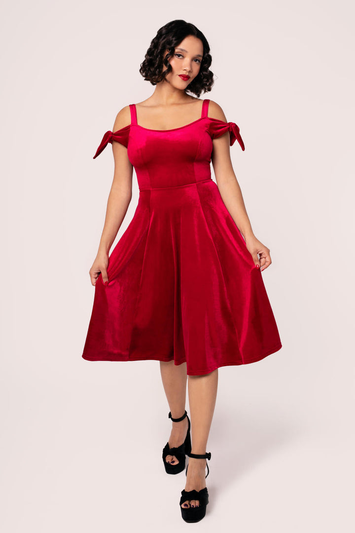 Side view of Hell Bunny Carrie red velvet midi dress showing fitted bodice and flared skirt