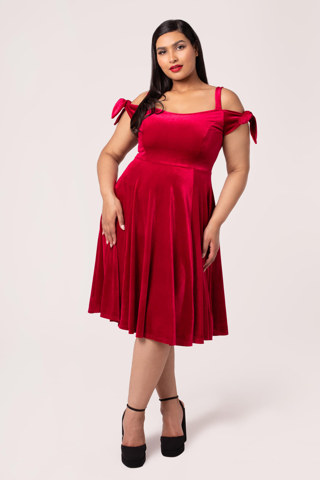 Plus size model wearing the Hell Bunny Carrie red velvet midi dress